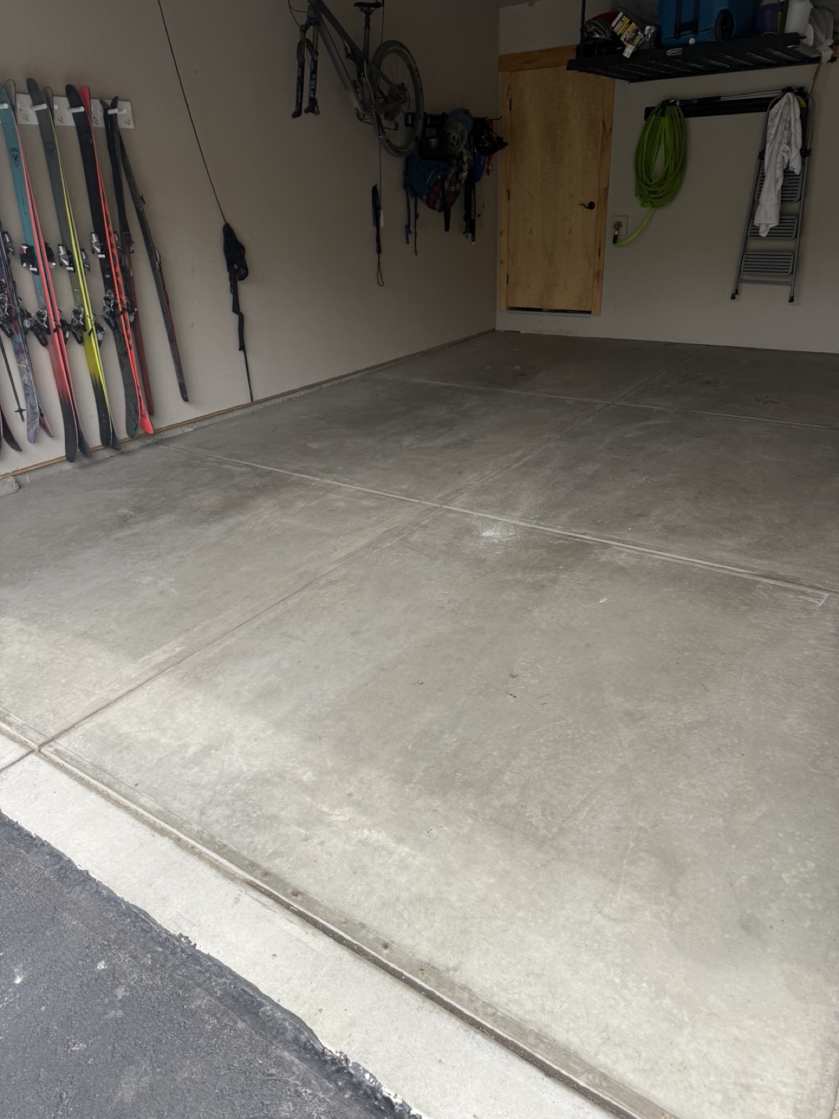 Before — bare concrete two-car garage floor in Silverthorne CO with ski storage